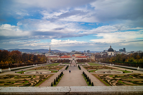 Amazing landscape with view to Unteres Belvedere and garden parterre of regular planting of trees and flowers in Vienna, Austria on a background of autumn cloudy sky.