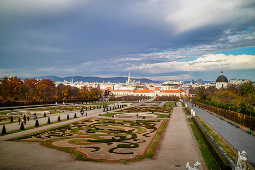 Wonderful landscape with view to Unteres Belvedere and garden parterre of regular planting of trees and flowers in Vienna, Austria on a background of grey autumn cloudy sky.