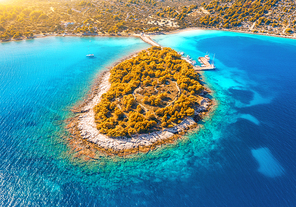 Aerial view of beutiful small island in sea bay at sunset in autumn in Murter, Croatia. Top view of clear blue water, orange trees, mountain, sandy beach, boats and yachts in fall. Tropical landscape