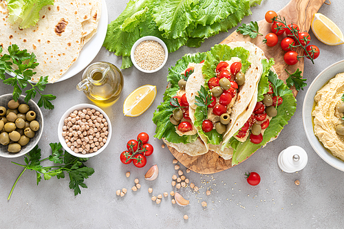 Tortilla wraps with chickpea hummus, fresh tomatoes and olives, vegan food