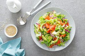 Salmon avocado salad with salted fish, fresh lettuce and red onion