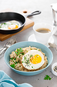 Savoury oatmeal with fried eggs sunny side up for breakfast
