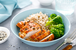 Baked chicken breast lunch bowl with pearl barley and broccoli