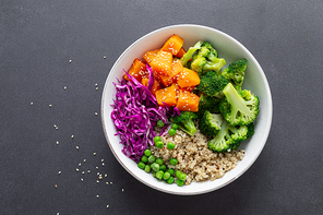 Vegetarian quinoa and broccoli lunch Buddha bowl with baked butternut squash or pumpkin, green peas and red cabbage, top down view