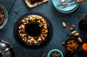 Christmas chocolate bundt cake with ganache decorated with oranges, berries and rosemary