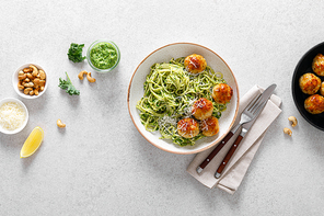 Chicken meatballs with pasta and green kale cashew pesto sauce, top view