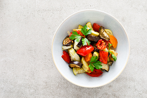 Baked vegetables salad with fresh parsley. Top view