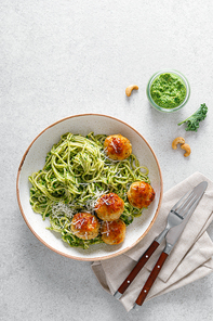 Chicken meatballs with spaghetti and green kale cashew pesto sauce. Top view