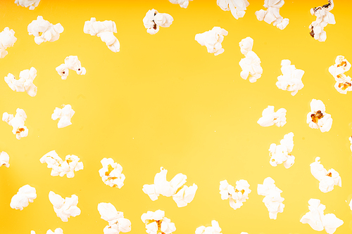 Scattered popcorn frame over plain yellow background