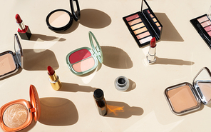 Minimal cosmetic scene with make up brushes, blush, powder, eye shadows, lipstick