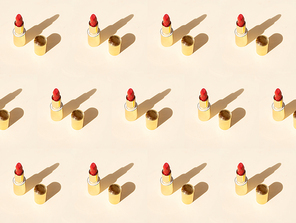 Minimal modern cosmetic scene with lipsticks over beige background pattern