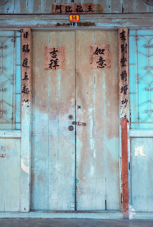Grungy and ragged wooden building with the asian inscriptions