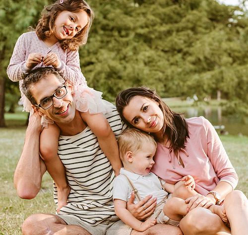 Portrait of cheerful family resting in the summer park