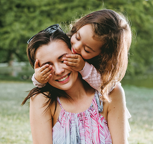 Mother and daughter having a great fun in the summer park