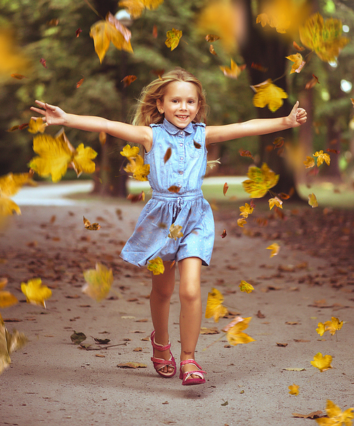 Cheerful little child in an autumn, colorful park