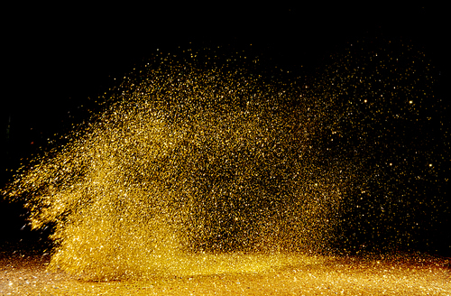 Golden, shining powder scattered over the dark background