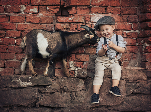 Cute little gentleman with a friendly goat