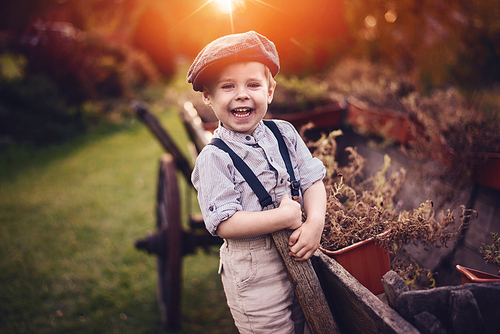 Cute, little gentleman relaxing a spare time on a farm