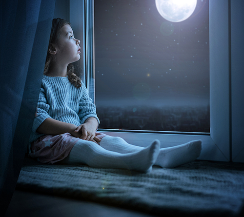 Portrait of a cute little kidl looking at the night moon