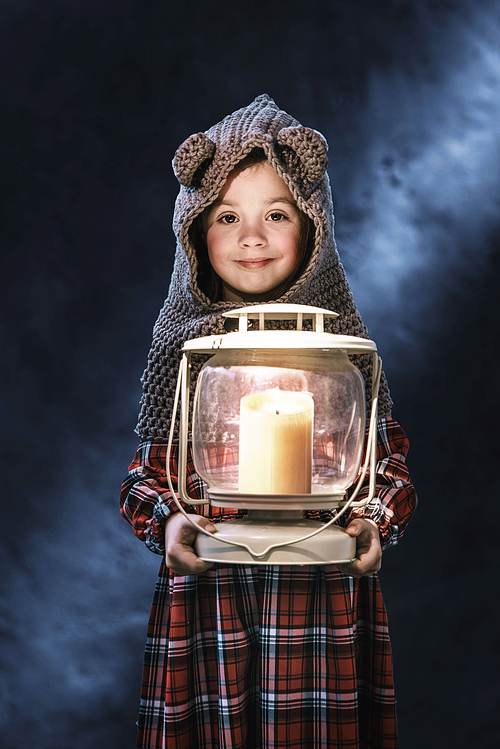 Conceptual portrait of a cute, little girl holding a torch