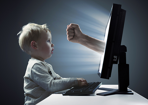 Cute, little boy looking at the display  monitor - Internet violence symbol