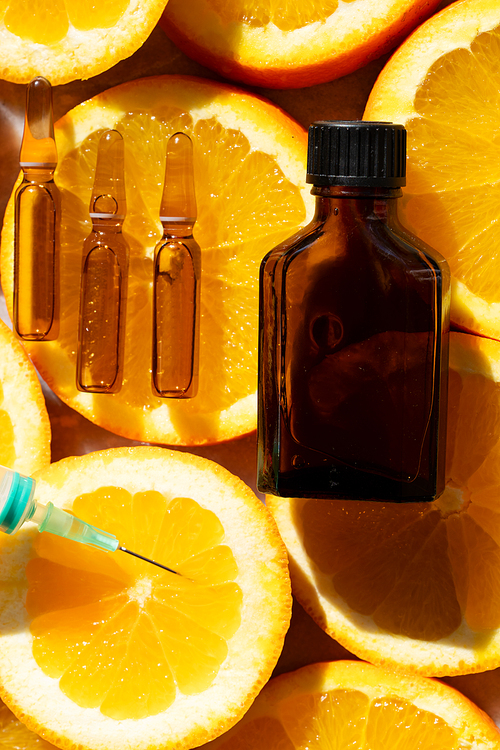 Citrus fruit vitamin c serum oil beauty care in ampullas and bottle close up, anti aging natural cosmetic.