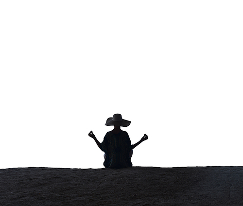 Calm, young woman meditating on a tropical beach