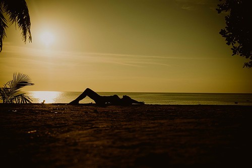 Relaxed, young woman meditating on a tropical beach