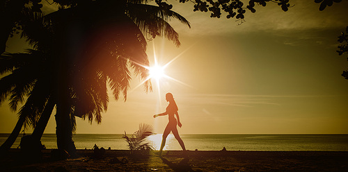 Flexible woman training on a tropical beach