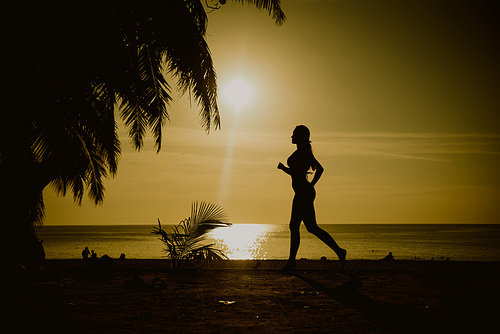 Flexible woman training on a tropical beach