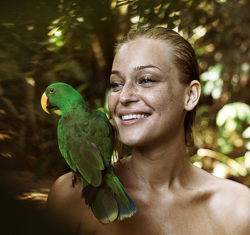 Portrait of a sensual, blonde with a parrot on shoulder