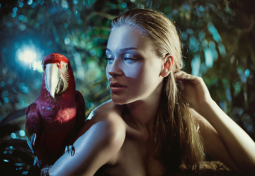 Sensual woman with a colorful ara parrot