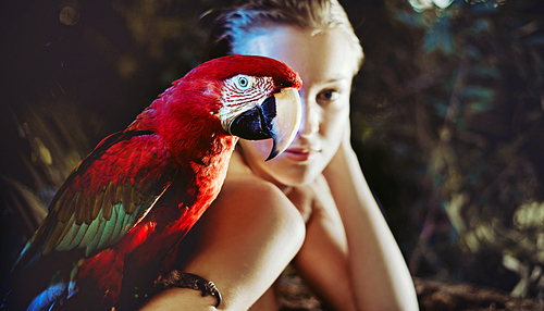 Sensual woman with a colorful ara parrot