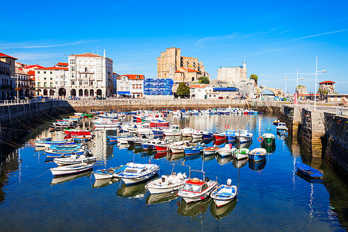 Boats at the port of Castro Urdiales, Santa Maria Church and Santa Ana Castle Lighthouse in Cantabria region in northern Spain.