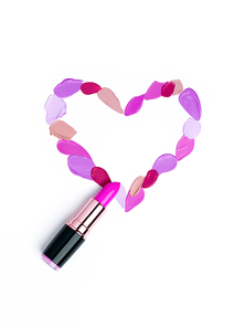 Valentine's Day background. Red and pink lipstick smeared in the shape of heart. Isolated on white background. Cosmetic products