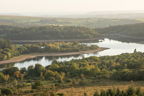 Beautiful Autumn sunset landscape image of view from Leather Tor towards Burrator Reservoir in Dartmoor National Park