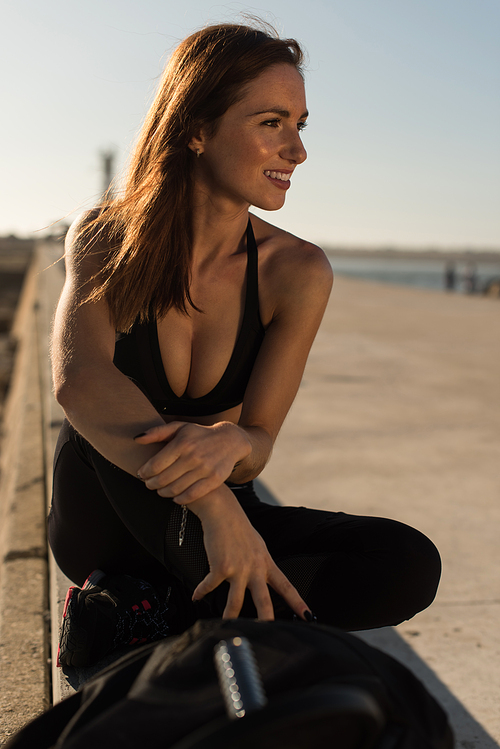 Fit woman enjoying the sunset after outdoor workout with weights