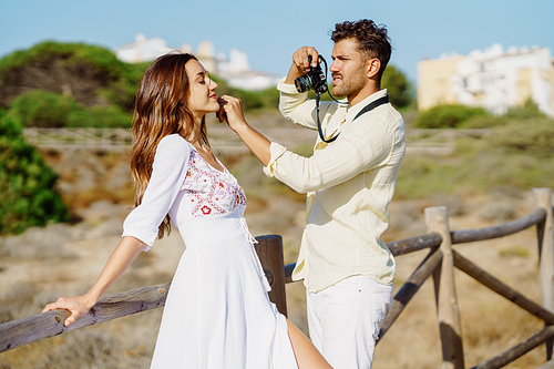 Man photographing his girlfriend on a lovers' trip Couple enjoying a natural environment.