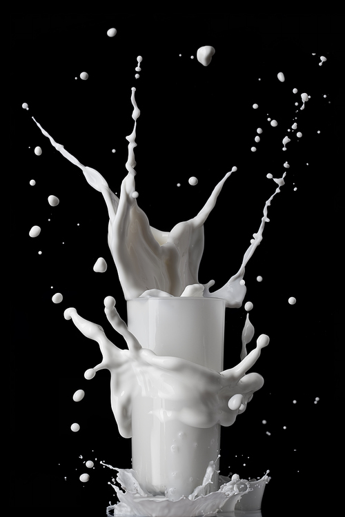milk splash in glass isolated on black background