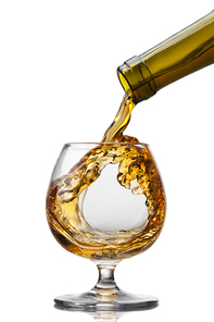 Cognac pouring into glass with splash isolated on white background