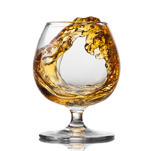 Splash of cognac in glass isolated on white