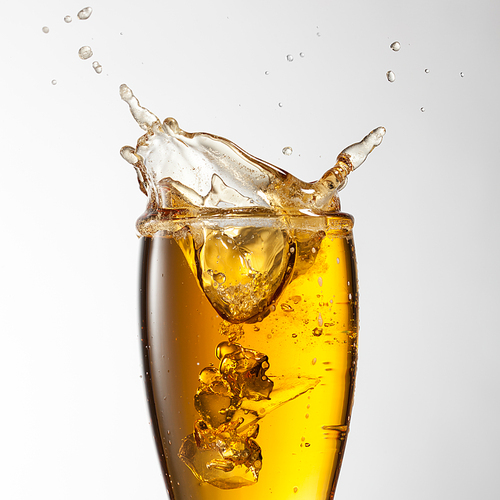 Beer splash in glass isolated on white