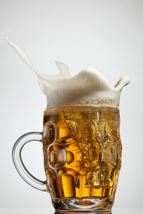 Beer splash in glass isolated on white