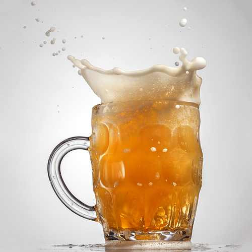 Beer splash in glass isolated on white