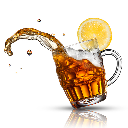 Beer splash in glass with lemon isolated on white