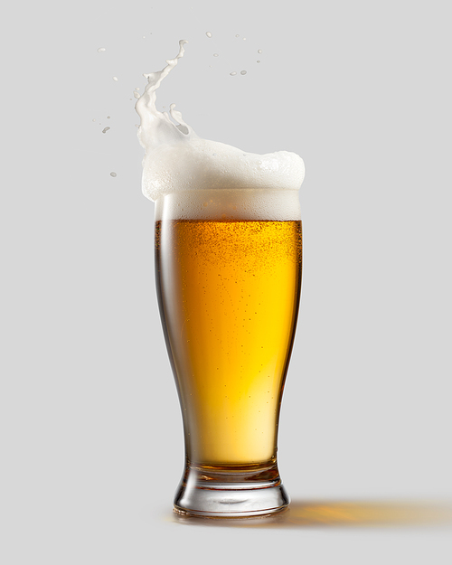 Frosty glass of light beer with foam and splashes, isolated on gray background