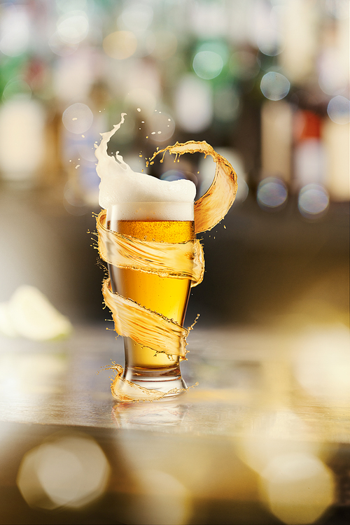 A cold glass of beer with beer foam and splash around on a wooden bar counter and blurred background with many bokeh