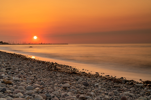 A beautiful long exposure sunset on a rocky beach on the Baltic Sea in Germany