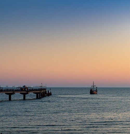 silhouette of an old Viking ship saling off into the sunset on the Baltic Sea