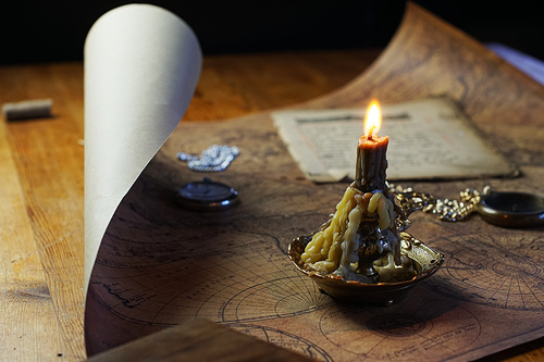 candle lie on old ancient map